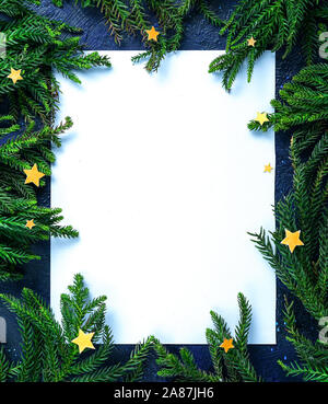 Empty Blank Card Surrounded by Christmas Tree Branches and Stars. Simple Christmas Composition Stock Photo