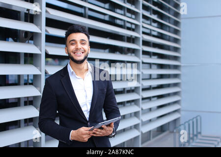 Arabic guy in business center stands smiling Stock Photo