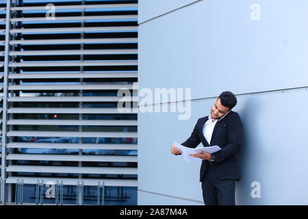 Handsome arabic man talks on mobile phone in business center Stock Photo