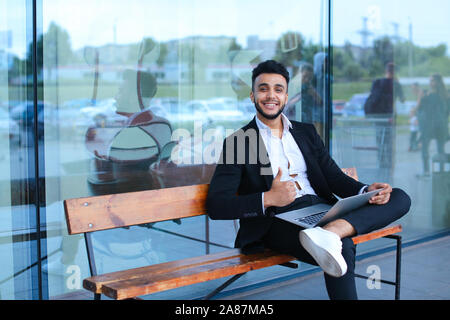 Cool guy arabic man uses laptop business center Stock Photo