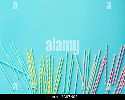 Colorful paper straws on blue background. Ecology product. Equipment for single use. Plastic alternative. Zero waste concept. Copy space for text or design. Top view or flat lay Stock Photo