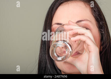 Woman drinking orange flavored vitamin mineral supplement from tablet dissolved in water. Stock Photo