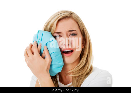 Woman with toothache pressing icebag to cheek. Dental illness and pain. Stock Photo
