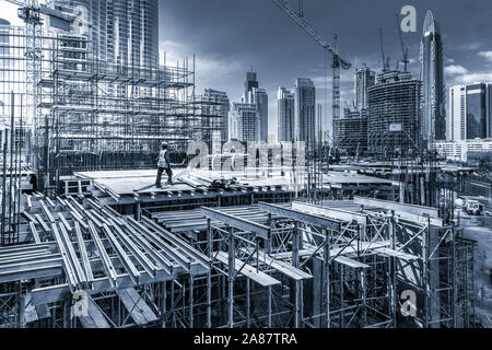 Laborers working on modern constraction site works in Dubai. Fast urban development consept Stock Photo