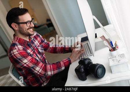 Young handsome designer working on project on computer Stock Photo