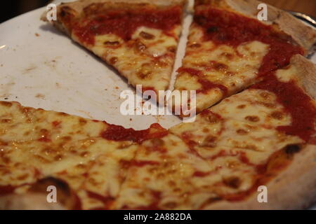 Sliced Pizza on a White Plate with one Slice Missing Stock Photo