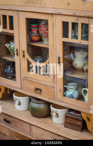 Wooden kitchen cabinet with ceramic plates and pots in kitchen in Serbia Stock Photo