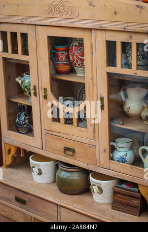 Wooden kitchen cabinet with ceramic plates and pots in kitchen in Serbia Stock Photo