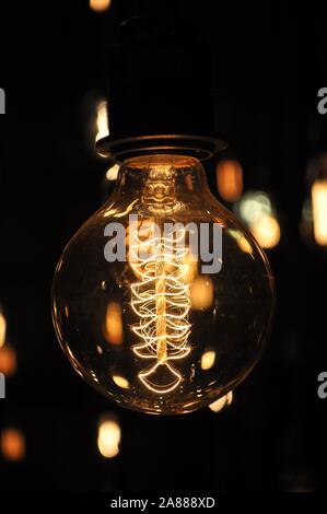 Close-up photo of a switched on designer decorative light bulb showing the filament details Stock Photo