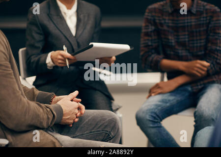 Close-up of people sitting on chairs and planning work together in team Stock Photo