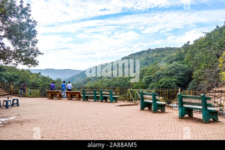 A beautiful lawn with park bench to sit and rest alone on a paved walk with lush greenery surrounded by Satpura and Vindhya mountain ranges in the bac Stock Photo