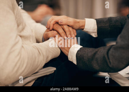 Close-up of mature man and woman holding hands and supporting each other in difficult situation Stock Photo