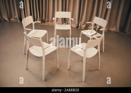 Image of white chairs standing in circle in the room they prepared for the meeting Stock Photo