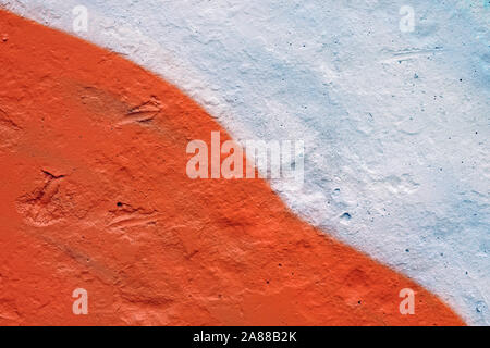 Wall painted white and orange diagonally divided background. The texture of the painted wall. Colored concrete wall background Stock Photo