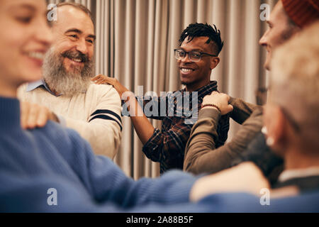African young man smiling at camera while playing with his colleagues during break during relaxed therapy Stock Photo