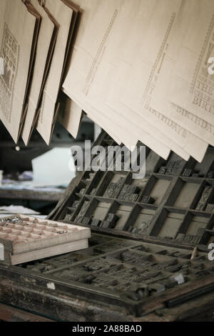 Moveable type. A retro scene of an old printers shop with typesetting equipment on display and printed documents hanging to dry. Stock Photo