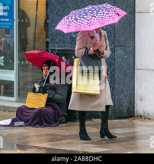 Preston, Lancashire. UK Weather. 7th Nov, 2019. People passing beggar, homeless & homelessness, people living on the streets, doorway, sleeping, poverty, unemployment, welfare, beggars, raggedly tramp, hobo, bum, vagabonds. unfortunate person in poverty, poor vagrant, tramp, drifter, shabby, ragged, tattered, unkempt, dowdy, shabby, poor, slovenly rough sleeper. Stock Photo