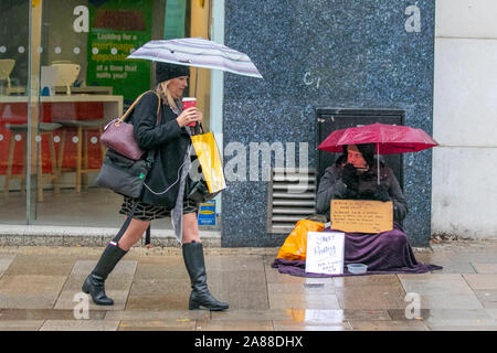 Preston, Lancashire. UK Weather. 7th Nov, 2019. People passing beggar, homeless & homelessness, people living on the streets, doorway, sleeping, poverty, unemployment, welfare, beggars, raggedly tramp, hobo, bum, vagabonds. unfortunate person in poverty, poor vagrant, tramp, drifter, shabby, ragged, tattered, unkempt, dowdy, shabby, poor, slovenly rough sleeper. Stock Photo