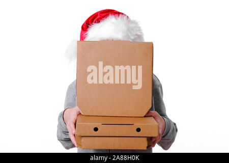 Christmas pizza and fastfood delivery. Unrecognizable man in santa hat hid behind pizza boxes in hands on white. Mock up for text or logo. Copyspace. Stock Photo