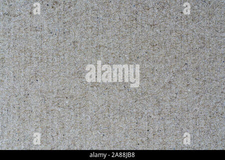 Light brown abstract background from sheet of recycled cardboard. Close-up detail view of texture recycled eco-friendly material pattern background. Stock Photo
