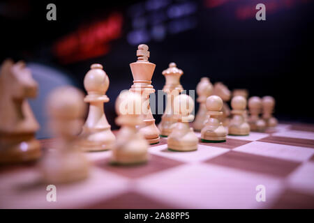 Shallow depth of field (selective focus) image with wooden chess pieces on a wooden table before a professional competition. Stock Photo