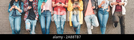 Group of friends using their smart mobile smartphones outdoor - Millennial young people addicted to new technology trends apps Stock Photo