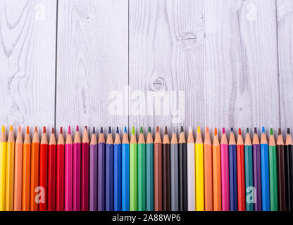 Color pencils in the background in white and gray wood, close up. Set of colored pencils, copy space. Color pencils. Top view, flat lay. Back to schoo Stock Photo