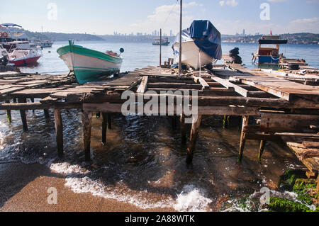 Old piers on the sea, with wrecked and usable boats Stock Photo