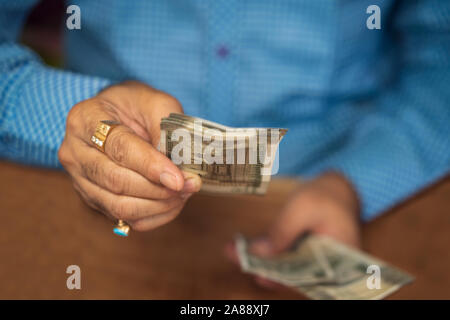 Indian man offering batch of five hundred rupee banknotes closeup picture with copy space. Background concept for bribe, corruption, hand giving money Stock Photo