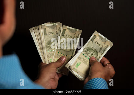 A person is counting new Indian 500 rupee notes in both hands. Indian currency counting concept background with copy space. Stock Photo