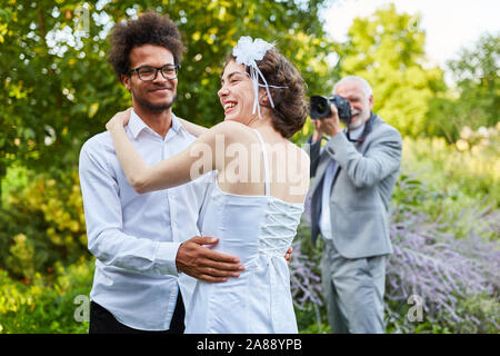 Wedding photographer photographs a happy bride and groom on the wedding day in nature Stock Photo