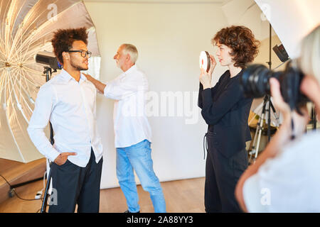 Man as a model posing in front of studio light for portrait photos in the photo studio Stock Photo