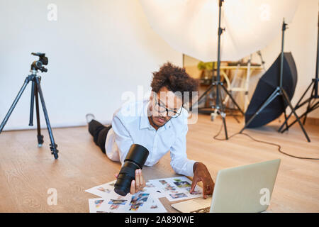 Young photographer or art director at picture selection in the photo studio Stock Photo