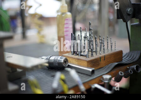 Drills Screws untidy on a table in a mechanic workshop Stock Photo