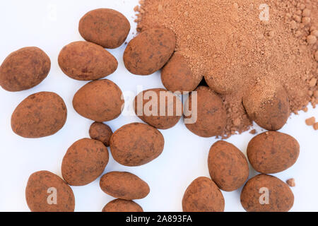 Almonds in dark chocolate top view. Delicious chocolates with nuts. Almonds in chocolate and cocoa close-up top view on a white background. Stock Photo