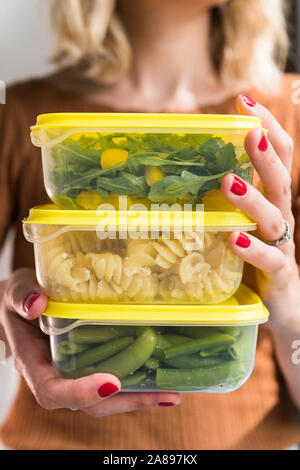 Woman holding stack of food in plastic containers Stock Photo
