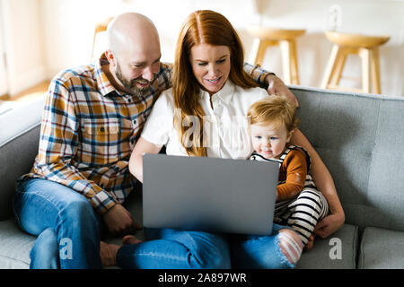 Family using laptop on sofa Stock Photo