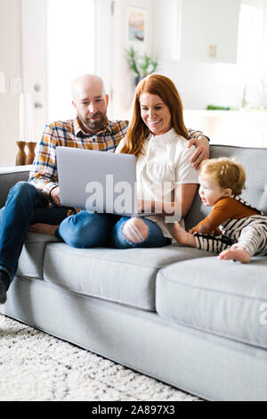 Family using laptop on sofa Stock Photo