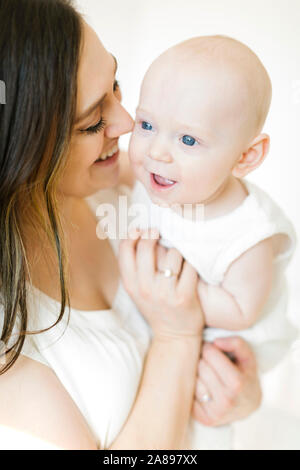 Smiling woman carrying her baby boy Stock Photo