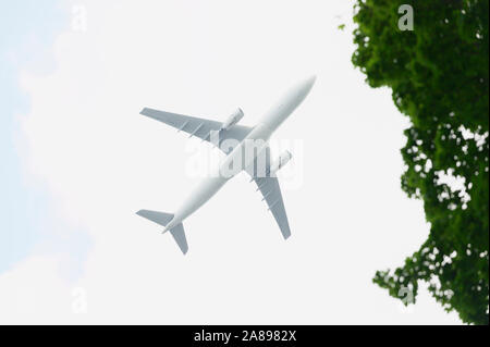 LOW FLYING AIRCRAFT AGAINST BRIGHT SKY, BOSTON, MA, USA Stock Photo