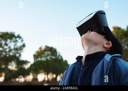 Boy wearing virtual reality simulator outdoors Stock Photo