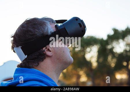 Mid adult man wearing virtual reality simulator outdoors Stock Photo
