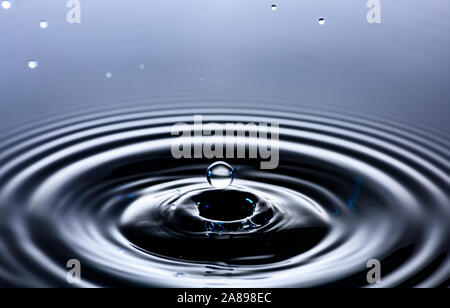 Water drop creating circular ripples Stock Photo