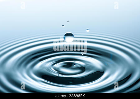 Water drop creating circular ripples Stock Photo