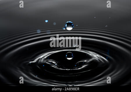 Water drop creating circular ripples Stock Photo