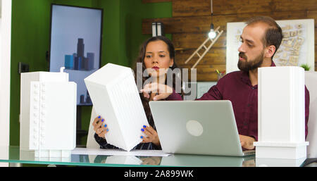 Team of creative designers working on new building models with 3D printed models Stock Photo