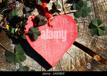 wooden heart with symbols of luck red heart, coin, clover and ladybug, Stock image