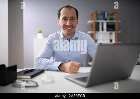 Happy Businessman Working On Laptop In The Office Stock Photo