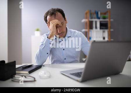 Front View Of A Stressed Businessman Sitting In Office Stock Photo