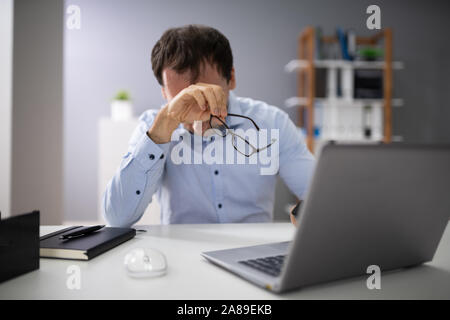 Front View Of A Stressed Businessman Sitting In Office Stock Photo